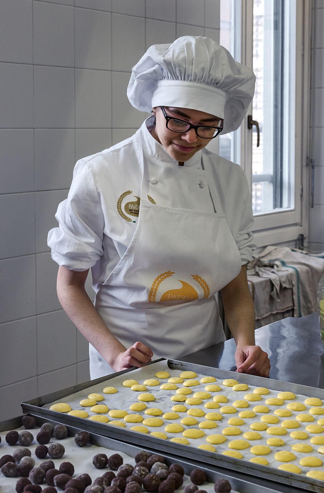 Allieva del corso di pasticceria al lavoro sulle teglie