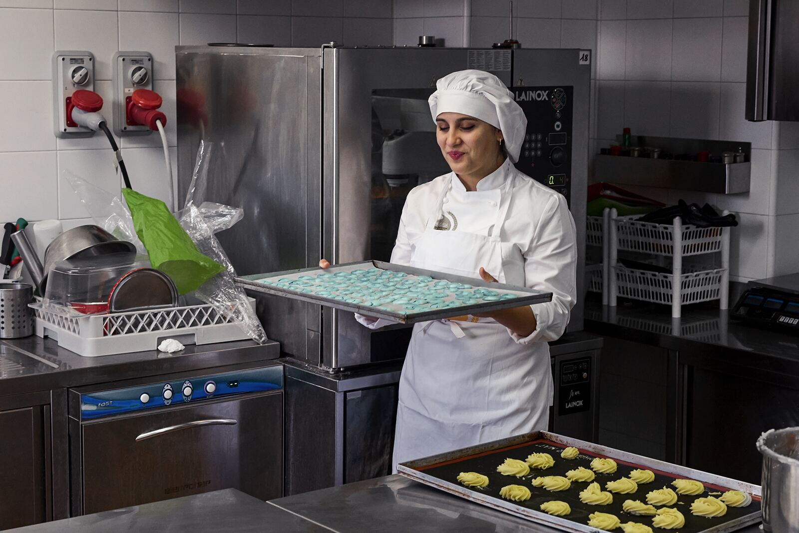 Allieva del corso di pasticceria con una teglia di biscotti